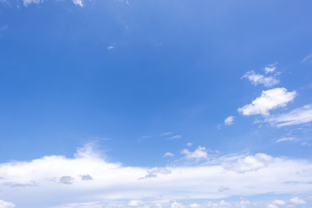 蔚蓝天空和云朵的全景视图，带有微小云朵的蓝色天空背景。蓝天中的白色蓬松云朵。迷人的天空和云朵之美的素材照片。图片下载