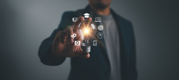 一位商人手持灯泡，周围环绕着教育和学习图标，象征着教育创新和绝妙的创意，一幅充满启发性的照片。图片下载