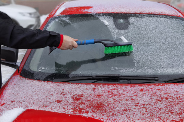 冬天汽车。男人在雪中刷车。特写照片图片下载