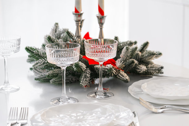 两只优雅的特高水晶玻璃杯，饰以节日常青装饰，适合圣诞晚宴图片下载