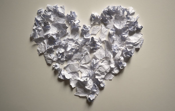 揉皱的白色纸片组成的爱心形状构图，在浅中性背景上投下阴影。照片。图片下载