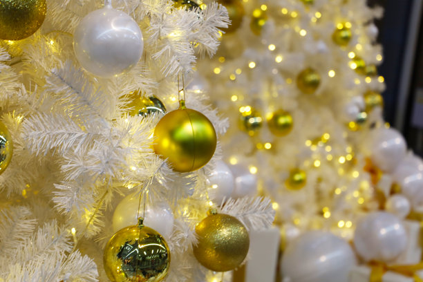 饰有金色装饰品和暖色灯光的白色圣诞树。图片下载