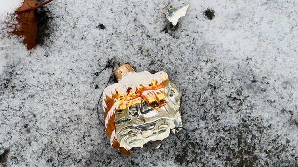 一辆火车形状的破碎圣诞玩具，落在雪地上——一张充满情感的冬季照片，适用于明信片设计、社交宣传和关于节日时刻脆弱性的内容。图片下载