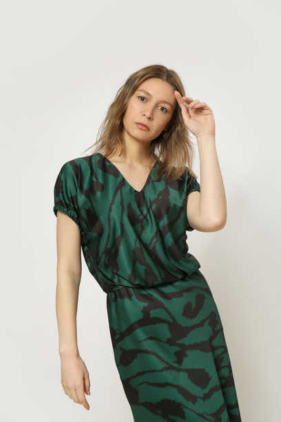 年轻女模特身穿黑绿相间丝绸缎面中长裙的系列工作室照片。图片下载