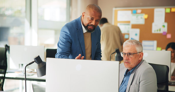 办公室里的男士们围着电脑讨论市场变化、股票价格或交易新闻，交易员、联合办公人士或成熟的专业人士利用科技解读财务报告、提供投资反馈或更新信息。图片下载