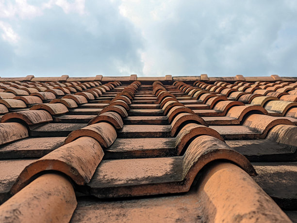 陶瓦。陶瓦屋顶的特写照片，背景是蓝天。老旧肮脏的陶瓦屋顶，留有文字空间。复制空间。图片下载
