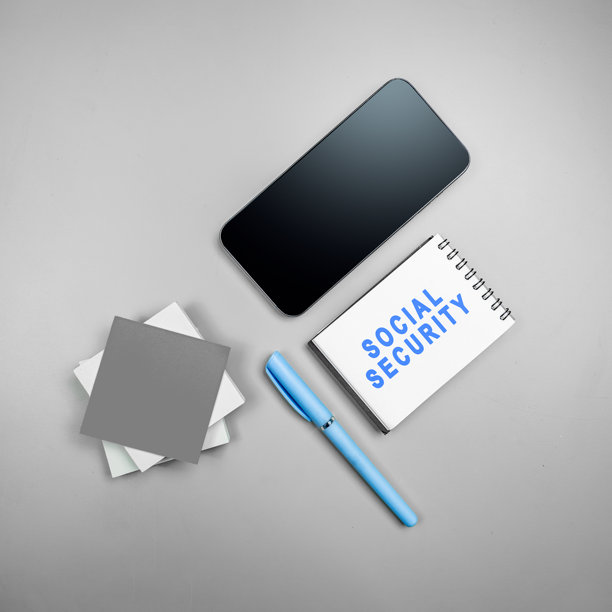 笔记本上印有“社会保障”字样，旁边放着一部手机，背景为白色。样机，可复制空间或模板。社会保障概念图片下载