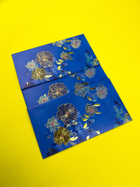 蓝色信封，带有金色花卉图案，在充满活力的黄色背景上呈圆形排列。适合全球穆斯林开斋节的节日概念照片。图片下载