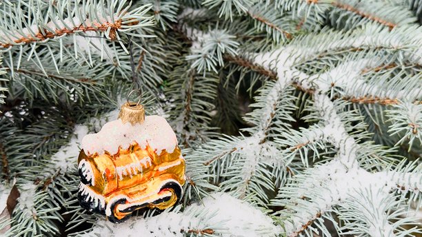 金色圣诞火车停在覆盖着雪的圣诞树上——用于假日广告、产品设计、包装、品牌的商业照片图片下载