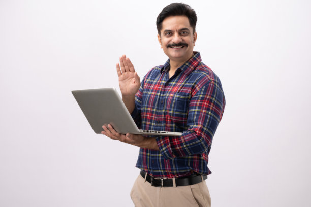 帅气的成年男性穿着格子衬衫，使用笔记本电脑，在白色背景下拍摄的照片素材图片下载