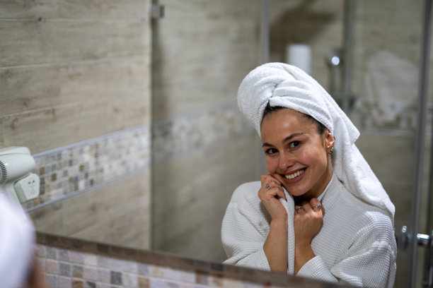 一位快乐的女士裹着毛巾享受晨间日常。素材图片图片下载