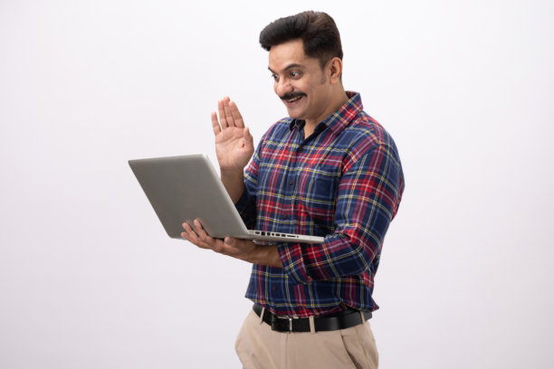 英俊的中年男子穿着格子衬衫，使用笔记本电脑，孤立在白色背景上的照片图片下载