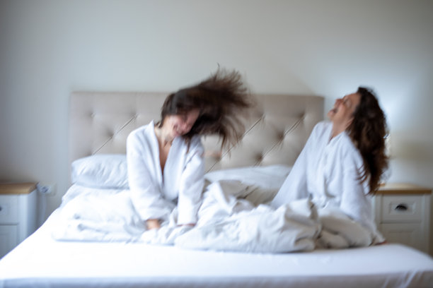 一群女性朋友在床上开怀大笑，玩得很开心。素材图片图片下载