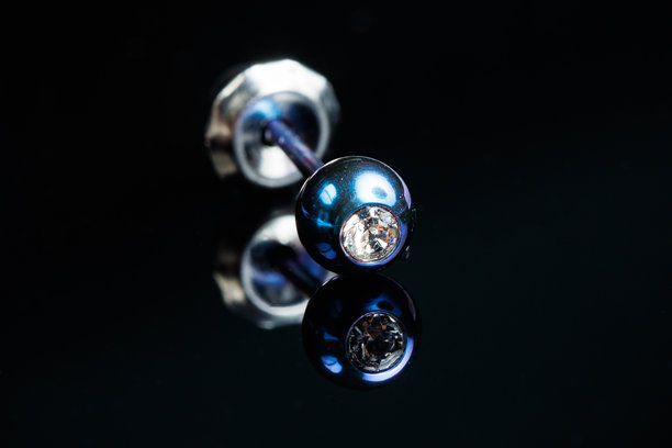 银耳环的微距照片，上面镶嵌着宝石，背景为黑色孤立图片下载