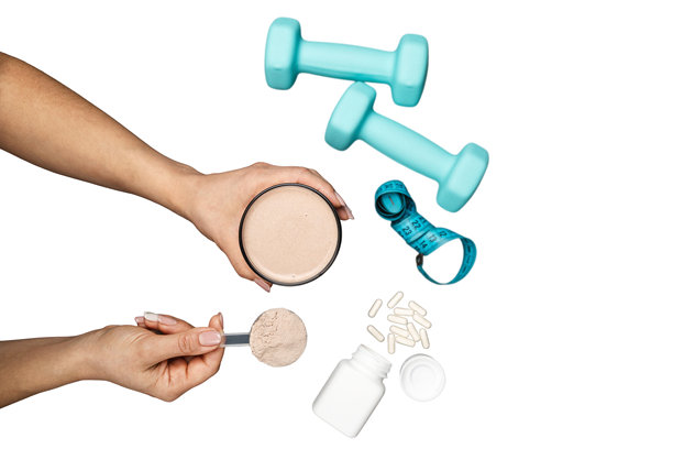 俯视女性手持蛋白粉饮料杯，杯中有巧克力乳清蛋白粉勺，白色背景上带有白色胶囊、哑铃和卷尺，运动营养概念图片下载