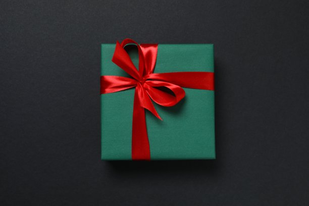 带有丝带的精美礼品盒，背景为黑色，并饰有圣诞装饰图片下载