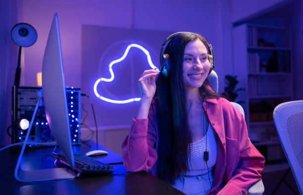 内容创作者或主播对着麦克风唱歌，同时与电脑屏幕互动图片下载