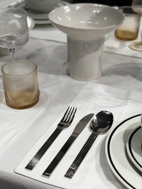 一张优雅的圣诞晚宴餐桌图片，摆放着餐位、餐垫、刀叉、节日餐巾和口布。图片下载