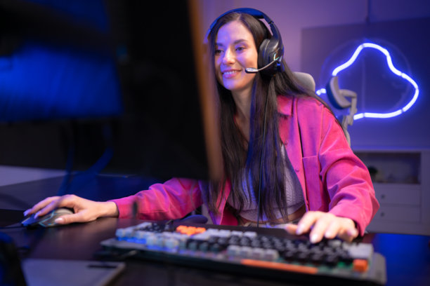 内容创作者或主播对着麦克风唱歌，同时与电脑屏幕互动图片下载