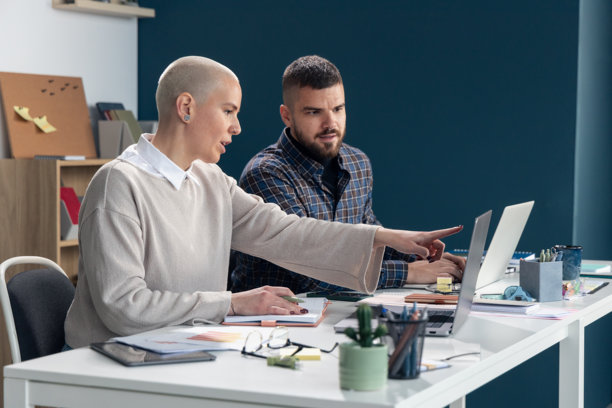 商业同事在笔记本电脑屏幕前协作，并用手指指向屏幕图片下载