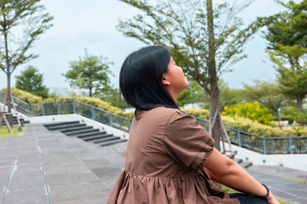 年轻的亚洲女性在绿地中放松，脸上洋溢着开心的笑容。美好生活方式、享受生活、绿色生活、健康理念、可持续发展。素材图片图片下载