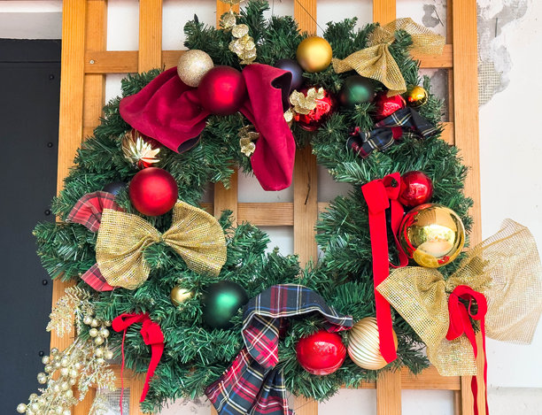 挂在木格子架上的节日圣诞花环，饰有红金两色装饰图片下载