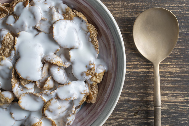 带酸奶的谷物釉面麦片，盛在盘子里。健康的早餐，碗里的全谷物麦片。图片下载