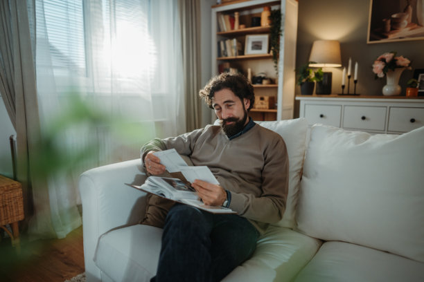 男人在家怀念过去，手持老照片图片下载