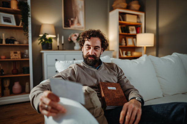 男人放松地坐在沙发上，看着旧照片图片下载