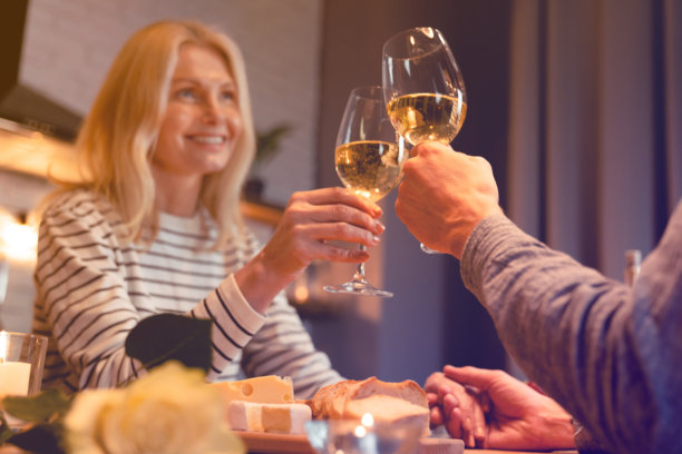 一对幸福美丽的情侣在浪漫约会中碰杯葡萄酒杯的专注照片。庆祝香槟酒精饮料用餐求婚庆典。图片下载
