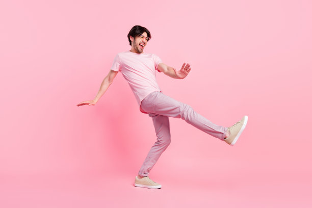 年轻男子全身侧面照片，面带快乐积极的微笑，享受音乐，舞者，俱乐部，在粉色背景上图片下载