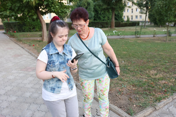 患有唐氏综合征的母女俩正在用智能手机查看她们的照片。图片下载