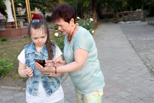 患有唐氏综合征的母女正在用智能手机看她们的照片。图片下载
