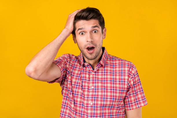 一名年轻男子手触头部的照片，表情震惊，忘记了记忆，孤立在黄色背景上图片下载