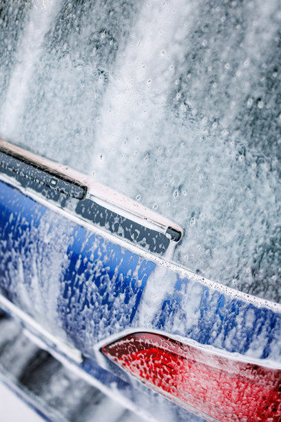 特写照片。带有厚泡沫的汽车零件。用于清洗脏污车辆的化学品。图片下载