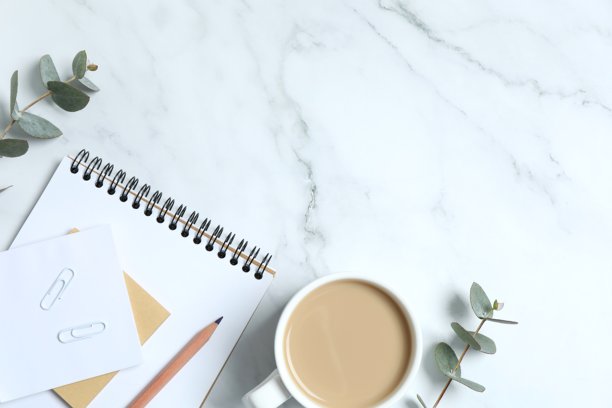俯视角度拍摄的白色背景工作空间照片，包含计划本、铅笔、咖啡杯和桉树叶，并留有空白区域。图片下载
