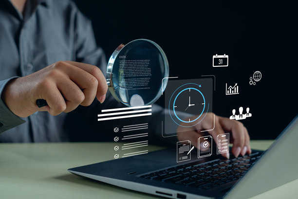 一位商人正在用放大镜分析笔记本电脑上的数字数据，其中包含代表审计、研究和数据驱动策略的分析、文档、时间和增长的虚拟图标。图片下载
