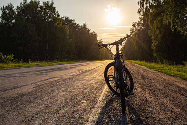 阳光下的公路自行车车把。在空旷的高速公路上骑自行车。自行车车把。高质量照片图片下载