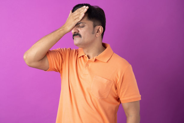 身穿橙色T恤的印度中年男子，在紫色背景下拍摄的照片素材图片下载