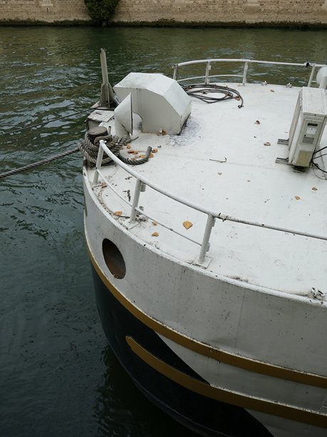 白色金属船漂浮在水面上，从后甲板视角拍摄的垂直照片图片下载