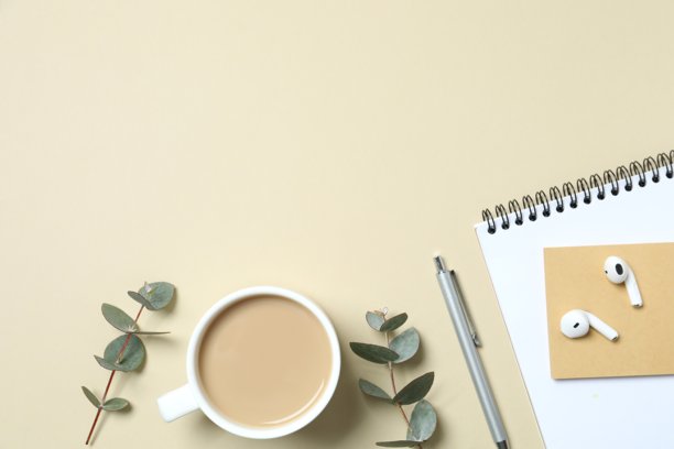 彩色背景上俯视的工作场所照片，包含计划本、钢笔、咖啡杯和桉树，并留有空白空间图片下载