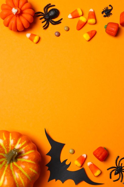 俯视的垂直照片，展示了色彩缤纷的万圣节糖果和南瓜装饰，节日氛围浓厚地摆放在紫色的背景上图片下载