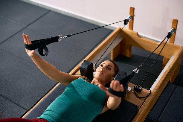 年轻孕妇在使用普拉提器械锻炼。图片下载