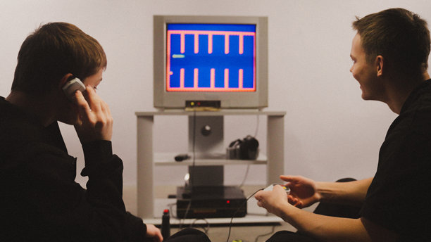 兄弟姐妹们一起在老式复古游戏机上玩CRT电视上的视频游戏图片下载