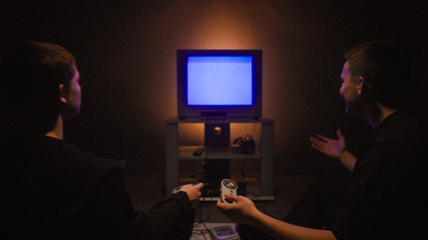 兄弟姐妹们在老式复古游戏机上玩电子游戏，屏幕是CRT电视，地板上放着一个便携式CD播放器，时间已是深夜。图片下载