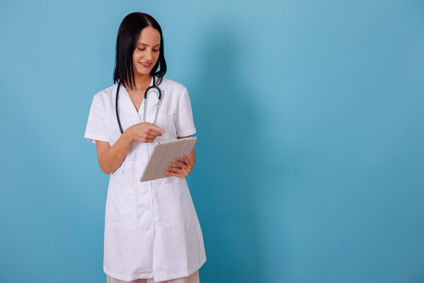 女医生使用数字平板电脑，指向屏幕，展示病人记录和医疗保健技术概念图片下载