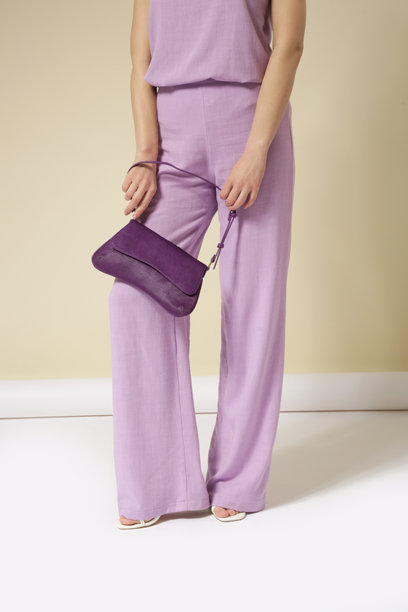 年轻女模特身着亚麻淡紫色套装的系列工作室照片，包括无袖上衣和舒适的长裤。休闲时尚的装扮，符合春夏流行趋势。图片下载