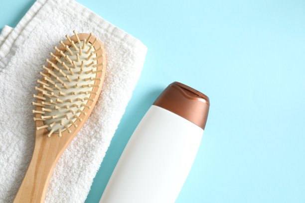 洗发水、毛巾和梳子放在彩色背景上，俯视视角图片下载