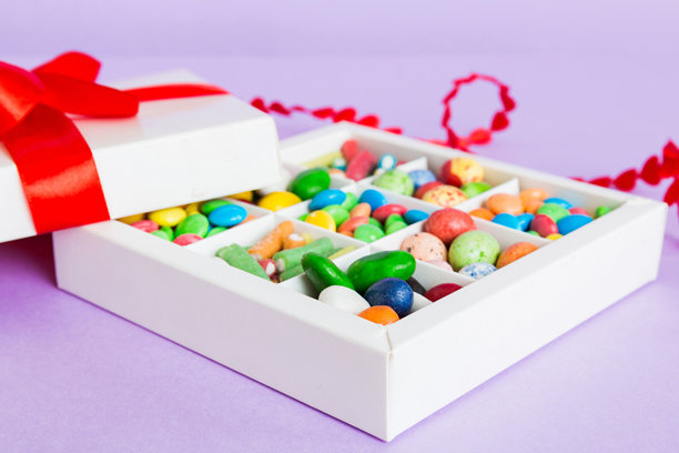 情人节主题构图：甜蜜糖果，附带蝴蝶结礼盒和红色毛毡心形，照片模板，背景。透视视图，包含复制空间图片下载