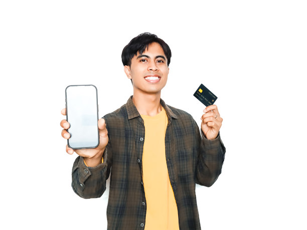 一位自信快乐的年轻亚洲男性，手持信用卡，展示着空白的智能手机屏幕模型，背景为白色，非常适合数字支付、在线购物和手机应用广告。图片下载